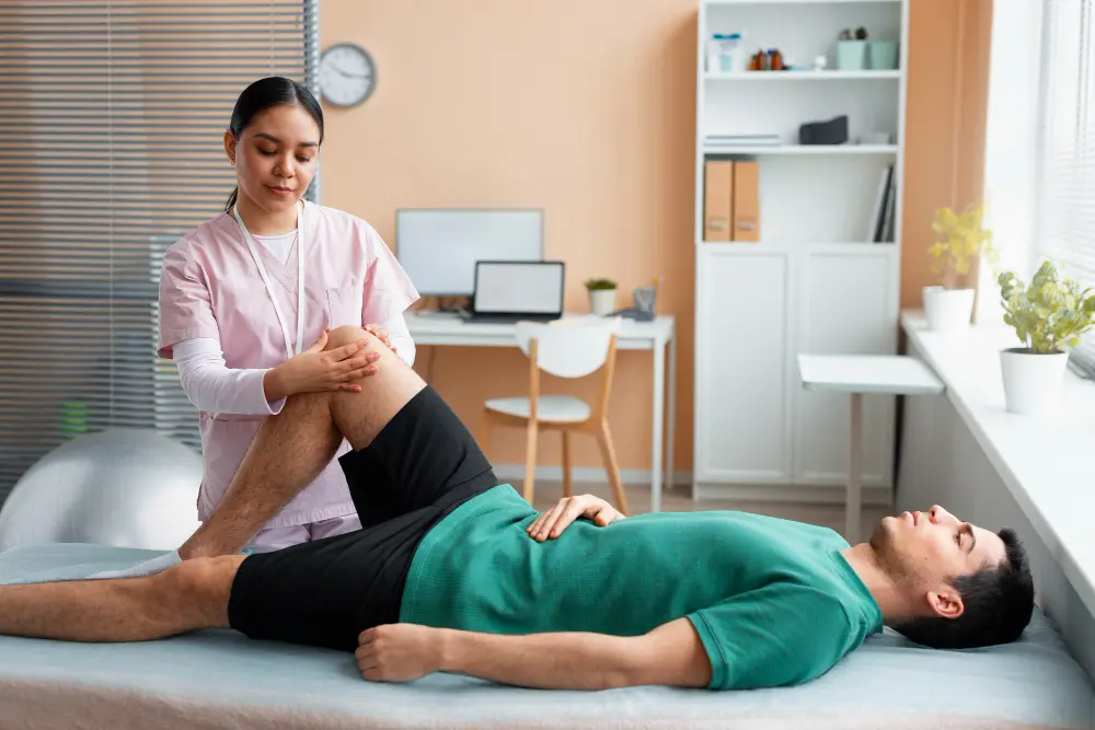 Chiropractic therapist performing a leg and hip mobility assessment on a patient during a treatment session in a wellness clinic.