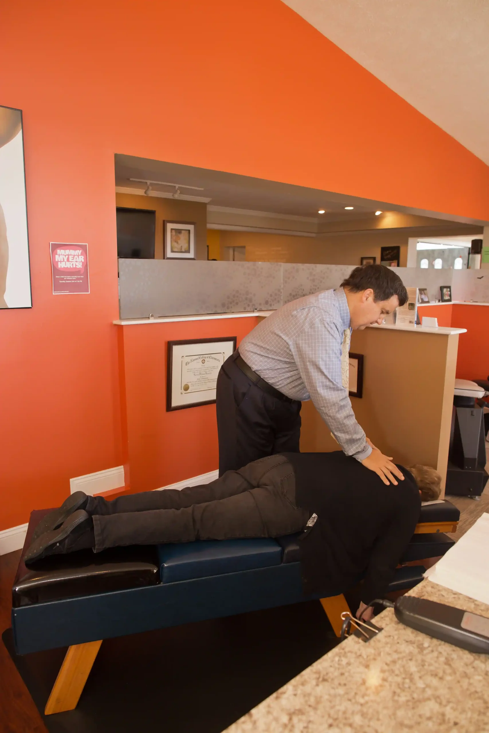 Chiropractor performing a spinal adjustment on a patient during treatment at a chiropractic clinic