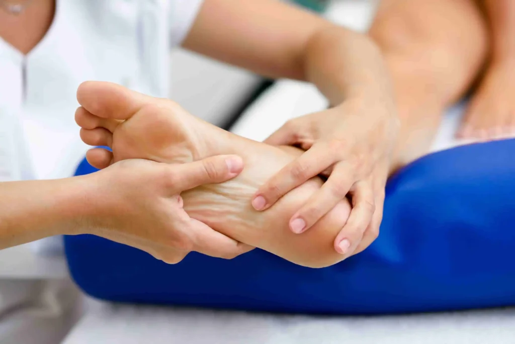 Chiropractor examining a patient’s foot as part of neuropathy treatment