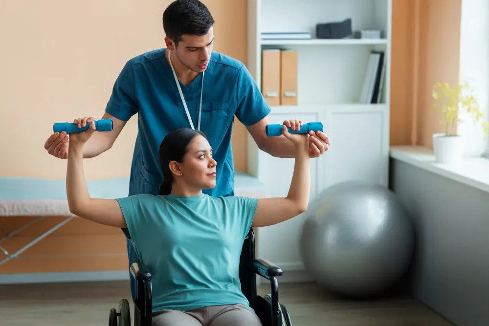 Physical therapist assisting a woman in a wheelchair with arm exercises using weights.