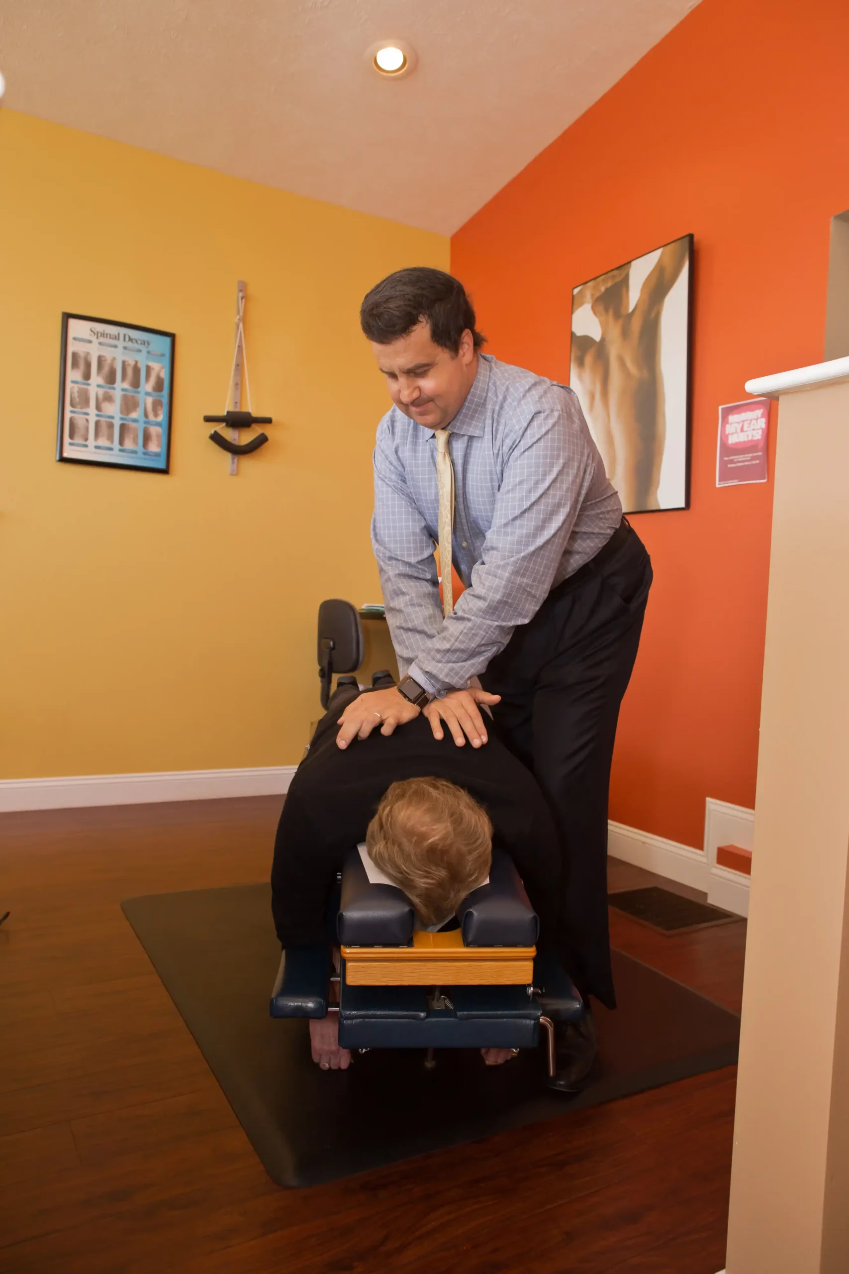 Chiropractor performing a spinal adjustment on a patient.