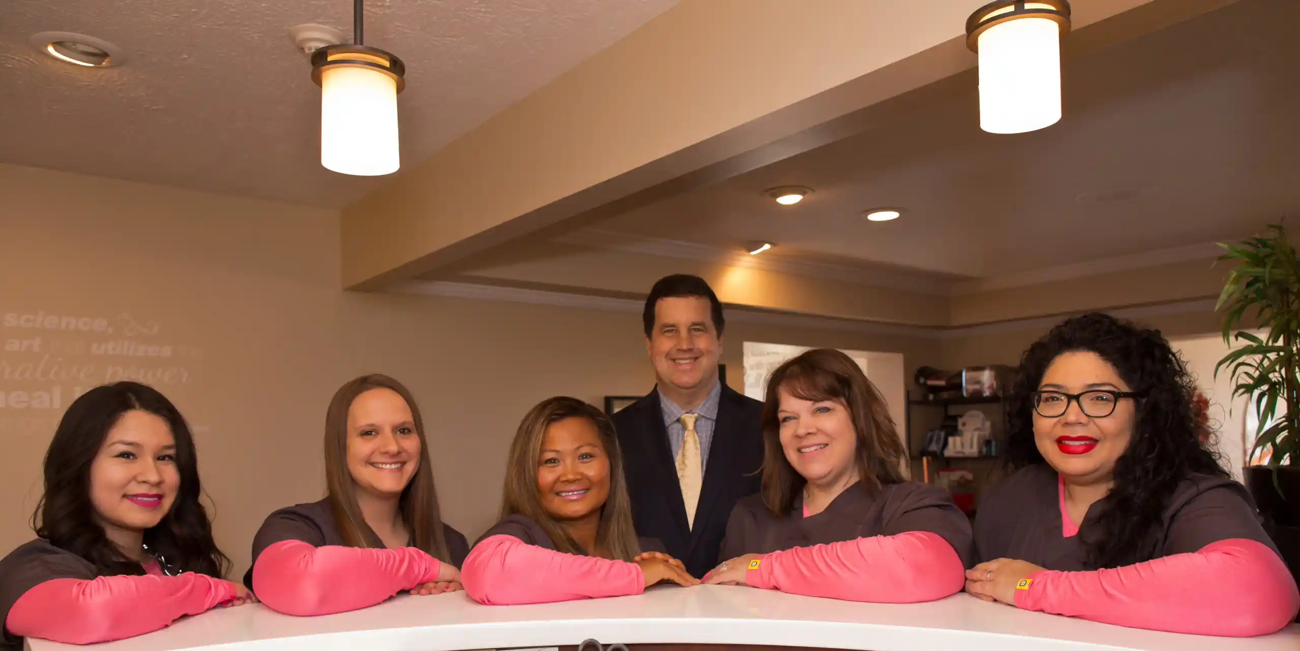 Friendly chiropractic clinic team standing at the reception desk, welcoming patients at Kaurich Chiropractic and Wellness Center