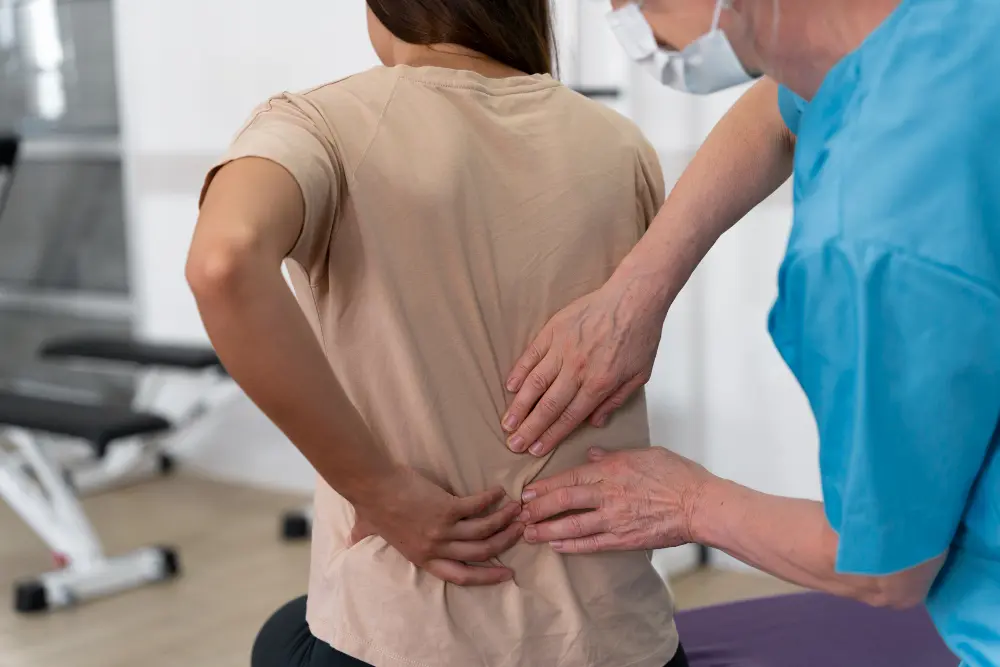 Healthcare professional examining a patient’s lower back to assess back pain and spinal discomfort.