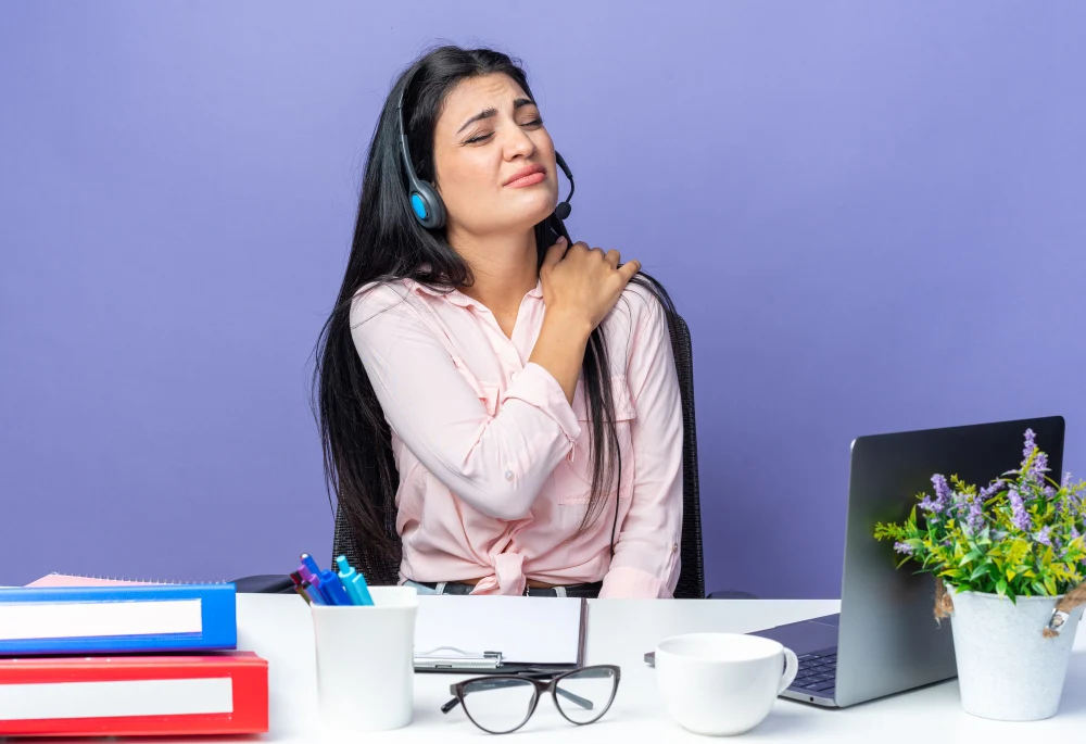Office woman working on laptop experiencing neck and shoulder pain