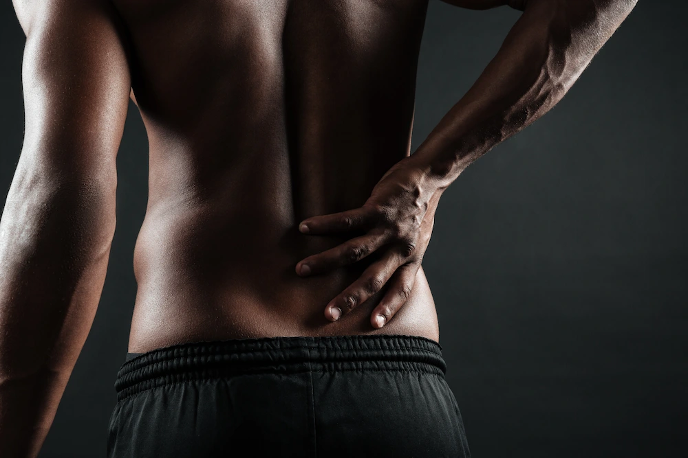 Man clutching back due to severe pain