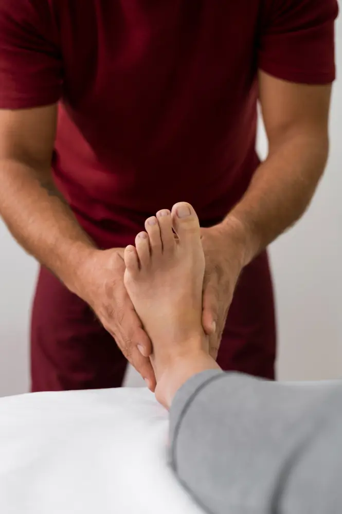 Healthcare provider examining and treating a patient’s foot during a neuropathy evaluation to help improve nerve function and reduce foot pain.