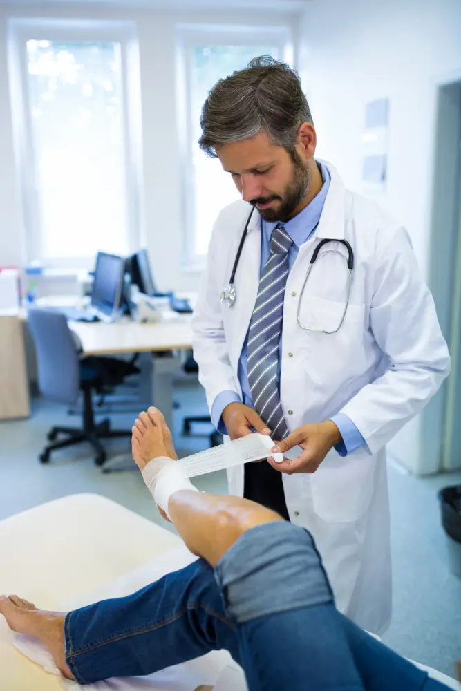 Doctor wrapping a patient’s injured leg with a bandage during a medical evaluation for a federal workplace injury claim.